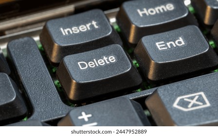 Focus on a delete key on a simple laptop computer keyboard, object macro detail, extreme closeup, nobody. Deleting files, removing content, digital data deletion simple abstract concept symbol