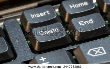 Focus on a delete key on a simple laptop computer keyboard, object macro detail, extreme closeup, nobody. Deleting files, removing content, digital data deletion simple abstract concept symbol