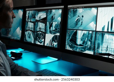 Focus on desktop computer monitors with cctv video system on screens standing in front of young working female guard