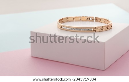 Focus on diamonds on golden bracelet on pastel colors background