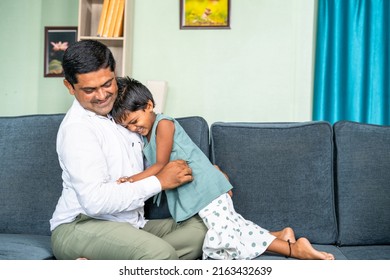 focus on fatherHappy Father playing with daughter by tickling on sofa - concept of family time, break, bonding and weekend relaxing.