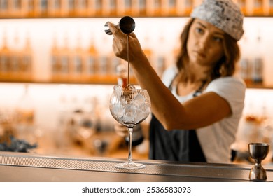 Focus on the foreground, where a tall glass is filled with ice on a bar counter - Powered by Shutterstock