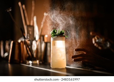 Focus on a glass with a cocktail covered with condensation, over which spray splashes fly