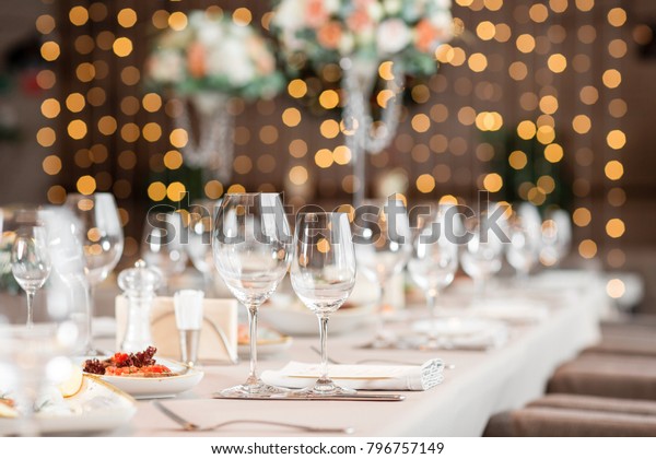 focus on\
glasses. Banquet table in the restaurant, the preparation before\
the banquet. the work of professional\
florists.