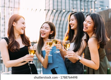 Focus On Glasses: Group Of Happy Asian Girl Friends Celebrating Party With Champagne Toasting Drinks At Outdoor Restaurant Together, Enjoy Chatting, Laughing With Smile. Young People Lifestyle 