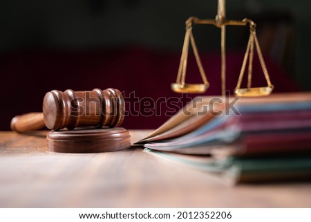 focus on hammer, group of files on judge table covered with dust - concept of pending old cases or work at judicial court.