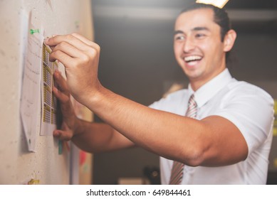 Focus on hand. Happines of Businessman smiling and preparing documents on wall for meeting in office.
