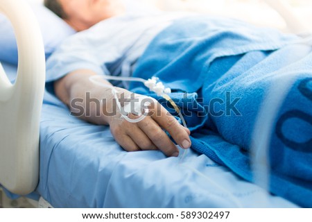 Focus on the hand of a patient in hospital ward