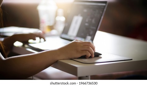 Focus On Hand Young Asian Woman Holding Computer Mouse Working At Home   With Computer Laptop On White Desk During Corona Virus Outbreak, Selective Focus, Dark Tone And Blur Background