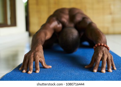 Focus On Hands Of African American Male Doing Yoga On A Blue Mat