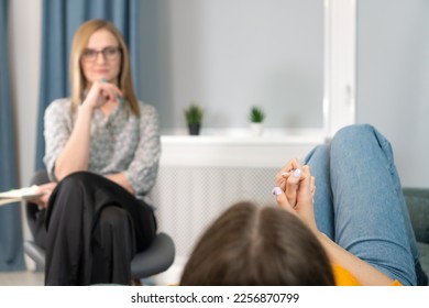 Focus on the hands of a patient lying on the couch at a psychologist's appointment. Woman is being consulted by a psychotherapist. Psychology, psychosomatics - Shutterstock ID 2256870799