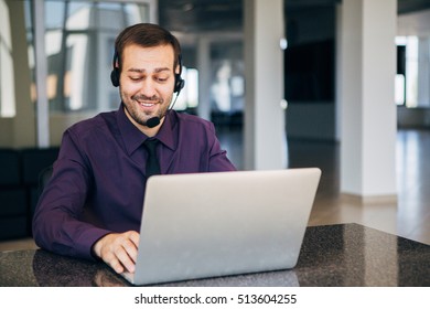Focus on a joyful call centre agent with his headset - Shutterstock ID 513604255