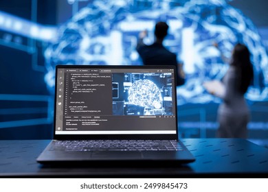 Focus on laptop running AI cognitive computing tech used by coworkers in blurry background. Close up of notebook used by programmers team to do data mining with self learning algorithms