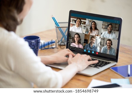 Focus on laptop screen with happy millennial mixed race friends communicating by video call software application during covid19 quarantine time, young woman enjoying distant virtual conference event.
