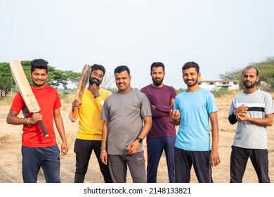 focus on man with yellow t-shirt, Team of cricket players with bat and ball coming and standing by looking at camera on field - concpet of competition, champions and active lifestyle. - Powered by Shutterstock