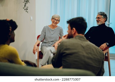 Focus on a mature senior woman talking on group therapy meeting and discussing addiction and mental health problems. Multiracial people talking about their mental health issues and looking for support - Powered by Shutterstock