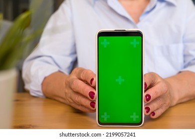 Focus On Mobile Phone, Unrecognizable Senior Woman Showing Green Screen Mobile Phone Concept Of Online App Or Service Promotion And Advertisement.