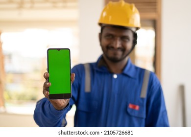 Focus On Mobile Pone, Smiling Plumber Showing Mobile Phone With Green Screen Mockup By Lookling At Camera - Concept Of Booking Of House Repair Service, App Advertising And Blue Collar Jobs