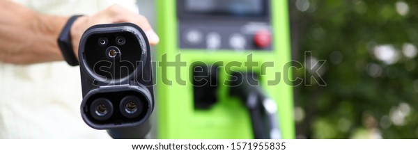 Focus on modern\
charge device for automobile. Auto filling station for electro\
vehicle. Environmental protection and newest transport technology\
concept. Blurred\
background