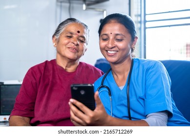 Focus On Nurse Happy Smiling Sick Senior Woman With Nurse Laughing By Watching Mobile Phone At Hospital - Concept Of Technology, Relaxation And Caretaker.