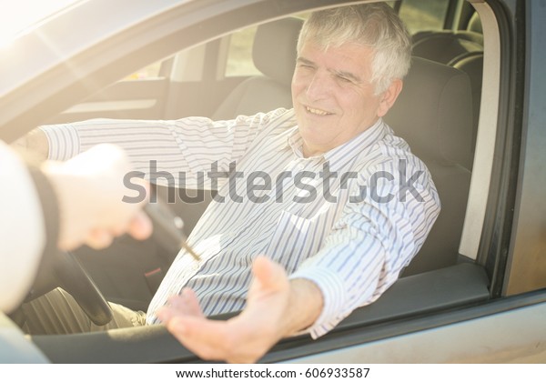 Focus is on older man with\
car key. 