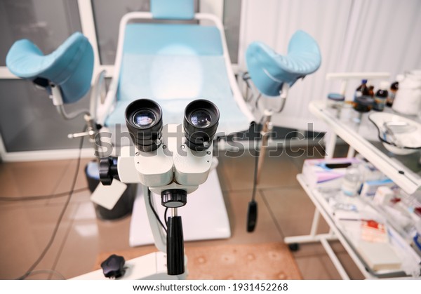 Focus on optical instrument for colposcopy in\
gynecological cabinet. Empty gynecology office with modern\
colposcope and medical tools. Concept of gynecology, obstetrics and\
medical equipment.