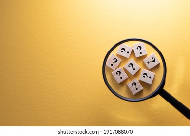 Focus on Question Mark symbol on a wooden tiles using magnifying glass against yellow background. Concept of Q and A, questions and faq - Shutterstock ID 1917088070