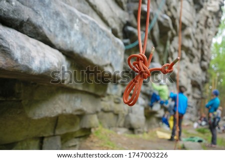  focus on red rope. Climber hanging on a safety rope. Climbing tools hanging on the climber