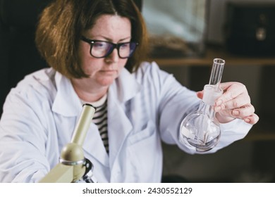 Focus on the test tube with scolopendra. Adult female researcher studying insect behavior in a test tube. Research Laboratory. Study of insects. - Powered by Shutterstock