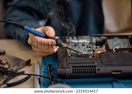 focus on unrecognizable engineer technician hands repairing faulty on laptop computer in electric device technology service, male using special tools. Maintenance notebook support service engineer