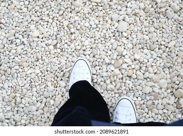 Focus On Girl’s White Shoes Step On The  White Stone Ground