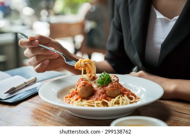 Focus On Woman Eating Spaghetti With Journal 