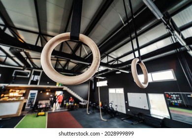 Focus On Wooden Sports Hoops Hanging From The Wall In An Urban Modern Indoor Gym With No People. Sports Equipment In Various Colors In A Modern Gym Concept