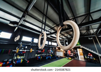 Focus On Wooden Sports Hoops Hanging From The Wall In An Urban Modern Indoor Gym With No People. Sports Equipment In Various Colors In A Modern Gym Concept