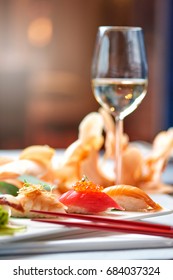 Fokus auf einen Sushi-Set und ein Glas Weißwein im Sonnenlicht