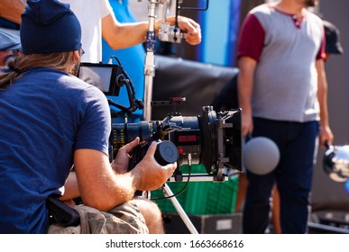 Focus Puller Hold The Wireless Follow Focus System During The Filming Process


