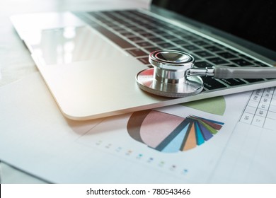 Focus Stethoscope Doctor Table On Laptop Computer With Report Analysis And Money About Healthcare Costs And Fees In Medical Hostpital Office. Healthcare Budget And Business Concept