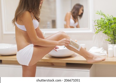 Focus Woman Waxing Leg In Bathroom 