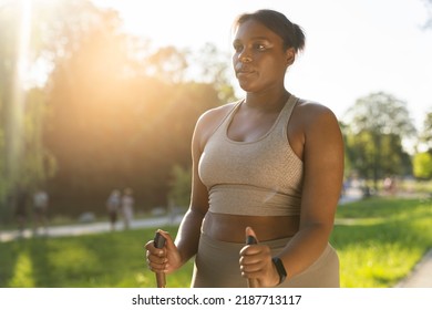 Focus Young African American Woman Exercising Nordic Walking In The Park In The Summer