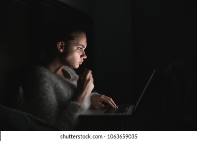 Focus Young Girl Sitting In The Dark And Working On Laptop