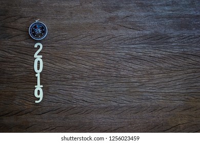 Focus Your Work Plan Concept : Top View, Flat Lay Compass And A Cut Wood Number 2019 On Wood Table And Copy Space.