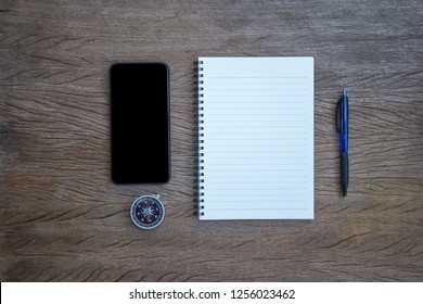 Focus Your Work Plan Concept : Top View, Flat Lay Office Supply Note Book, Pen And Compass And Smartphone With A Cut Wood Number 2019 On Wood Table. Personal Work Space For New Year Resolution.