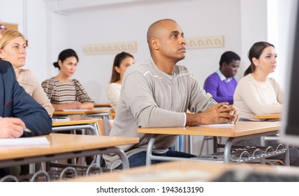 Focused Adult Latin American Man Listening To Lecture In Classroom With Group. Postgraduate Education Concept