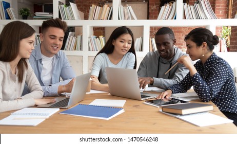 Focused African American Guy Showing Important Information To Indian And Asian Teammates On Computer Screen. Group Of Mixed Race Students Working Together On School Project, Doing Research At Library.