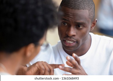 Focused african american man looking speaking to woman having business talk negotiating explaining, serious black guy having conversation with girlfriend friend discussing important issues at meeting - Powered by Shutterstock