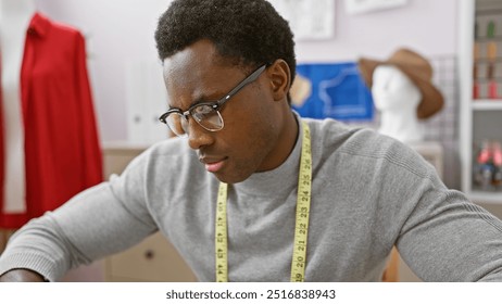 Focused african american man measuring fabric in a modern tailor shop, capturing his concentration and craftsmanship. - Powered by Shutterstock