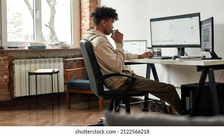 Focused African American Trader Drinking Energy Drink And Watching Data Index Chart Stock Market, Working At Home Office, Cryptocurrency And Digital Payment System Concept. Decentralized Finance