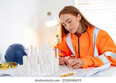 Focused architect designing urban landscape model at a bright workspace during the day - Powered by Shutterstock