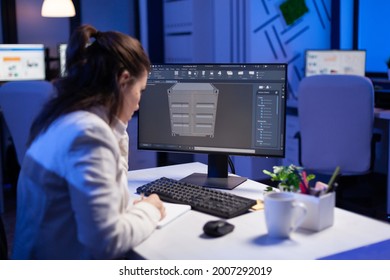 Focused architect working in 3D software developing prototype container design sitting at desk in business office. Technician engineer creating and studying project prototype, analysing scale model