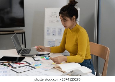Focused Asian designer developing user interface mobile applications Woman creates digital product design concepts and innovative solutions
